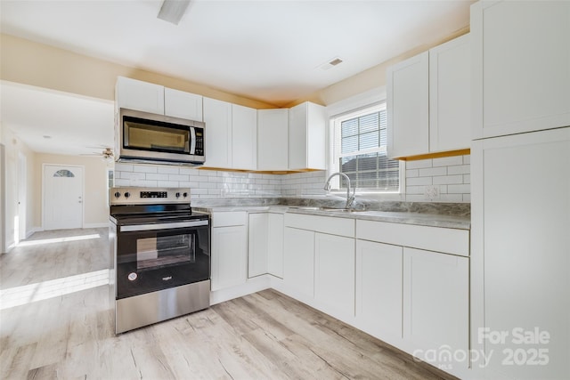 417 Baker Street Ext, Rock Hill, SC 29730 - kitchen featuring appliances with stainless steel finishes, light wood-type flooring, white cabinetry, and backsplash