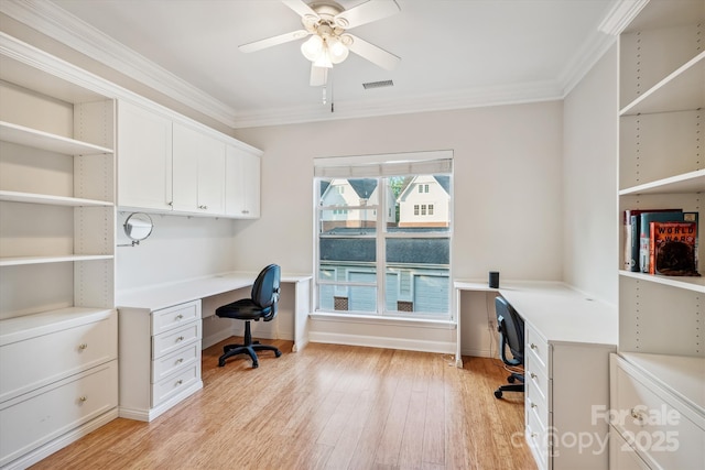 office space with light wood-type flooring, crown molding, visible vents, and built in desk