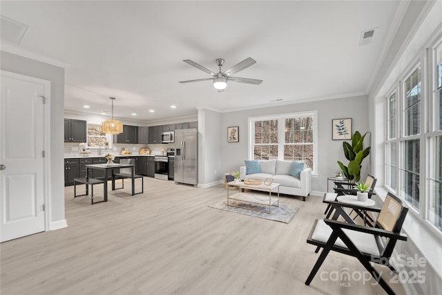 living room with crown molding, ceiling fan, and light hardwood / wood-style floors