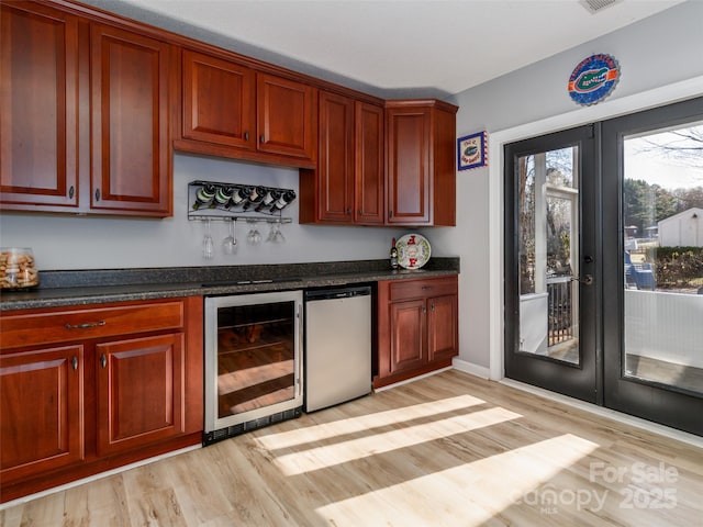 bar with wine cooler, refrigerator, french doors, a bar, and light wood-style floors