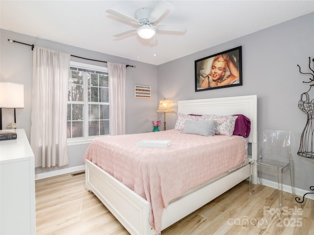 bedroom featuring baseboards, ceiling fan, and light wood finished floors