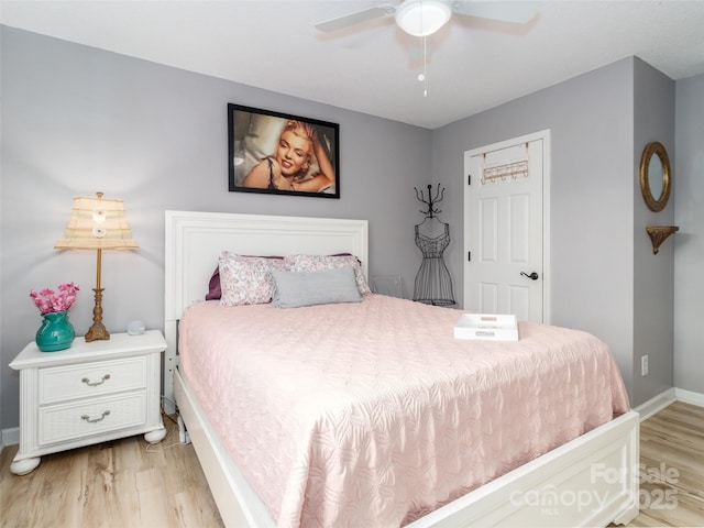 bedroom with a ceiling fan, light wood-style flooring, and baseboards