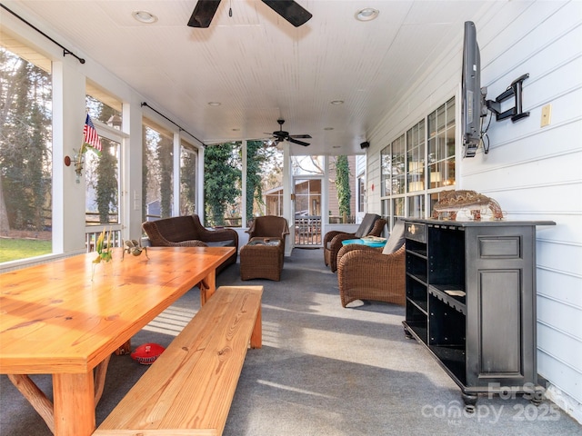 sunroom / solarium with a ceiling fan