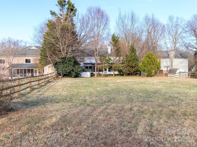 view of yard with an outdoor structure, fence, and a storage shed