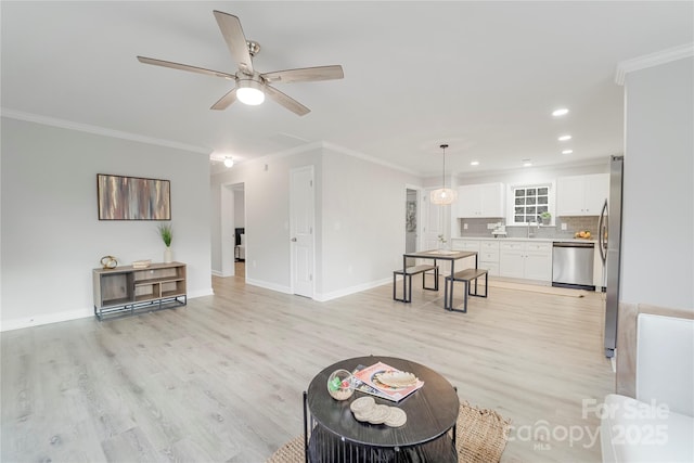 living room featuring ceiling fan, ornamental molding, and light hardwood / wood-style floors