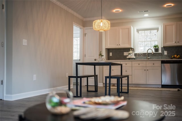 kitchen with white cabinetry, tasteful backsplash, crown molding, decorative light fixtures, and dishwasher