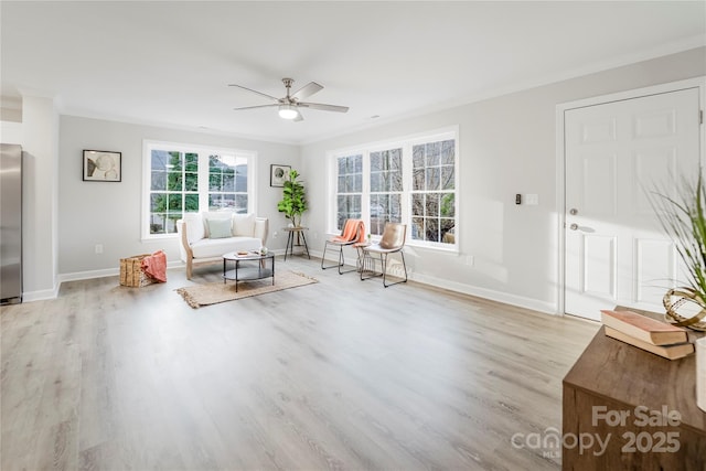 living area featuring crown molding, light hardwood / wood-style floors, and ceiling fan