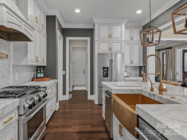 kitchen with white cabinets, high end appliances, under cabinet range hood, and a sink