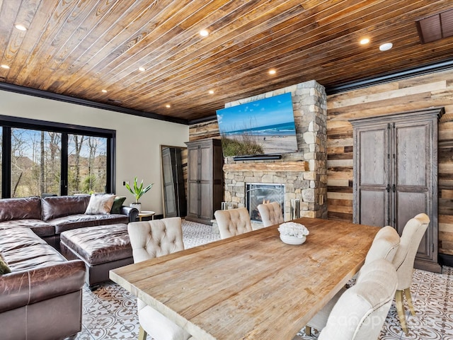 dining area featuring recessed lighting, a stone fireplace, wooden ceiling, and crown molding