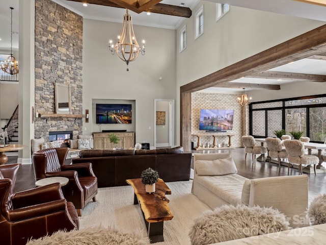 living room with a wealth of natural light, a stone fireplace, an inviting chandelier, and wood finished floors