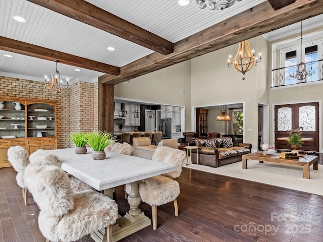 dining room with a notable chandelier, beamed ceiling, and dark wood-type flooring