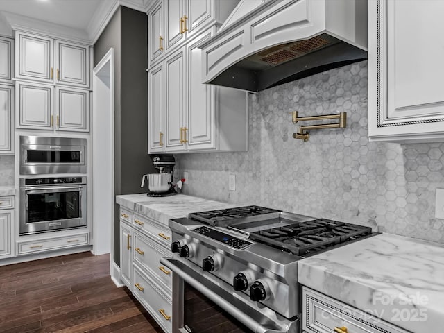 kitchen with custom exhaust hood, light stone countertops, dark wood-type flooring, and appliances with stainless steel finishes