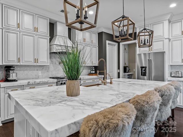 kitchen featuring a chandelier, dark wood finished floors, custom range hood, ornamental molding, and high quality fridge