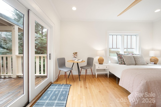 bedroom with multiple windows, access to exterior, hardwood / wood-style flooring, and ornamental molding