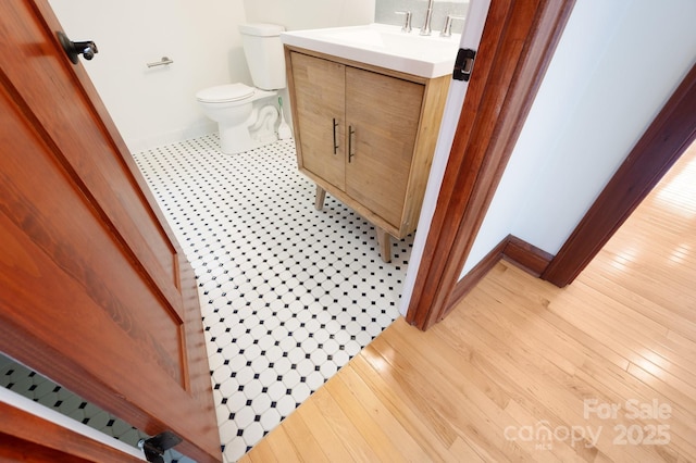 bathroom featuring vanity, hardwood / wood-style floors, and toilet