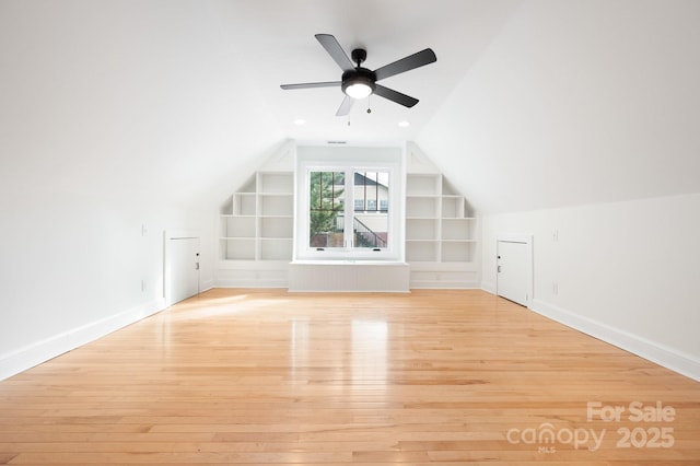 additional living space with ceiling fan, lofted ceiling, built in features, and light hardwood / wood-style flooring