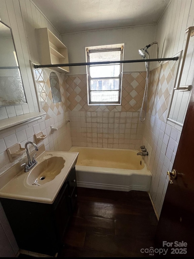 full bath with tile walls, shower / bathtub combination, wood finished floors, vanity, and backsplash