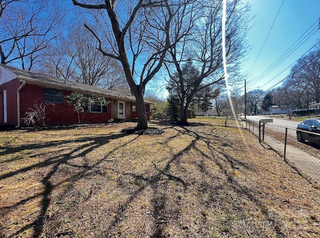 view of side of property with fence and brick siding