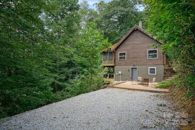 back of property with a patio and a fire pit