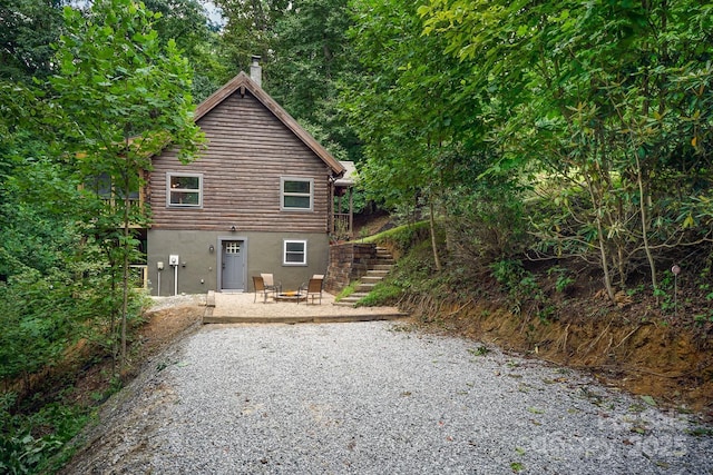 3925 Blackberry Crest Ln, Lenoir, NC 28645 - rear view of house with stairs, log siding, a chimney, a patio area, and stucco siding