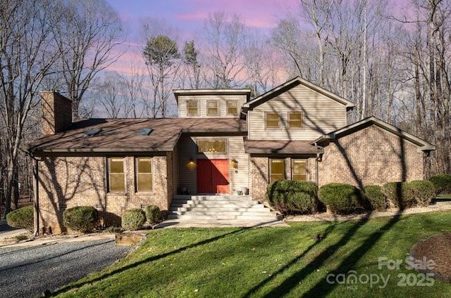 view of front of home featuring a front yard and brick siding