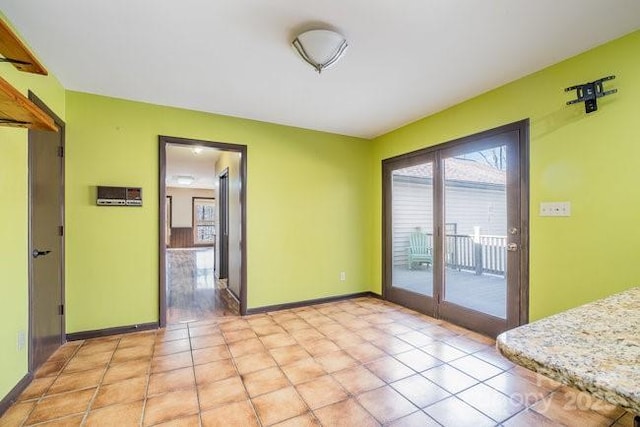 unfurnished room with baseboards and light tile patterned floors