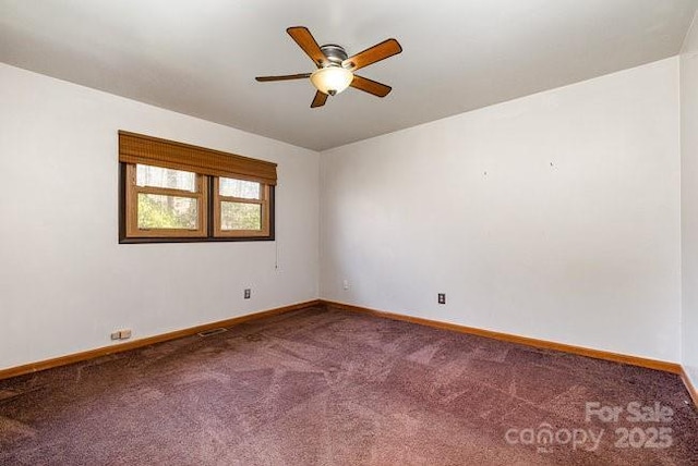 carpeted spare room featuring a ceiling fan and baseboards