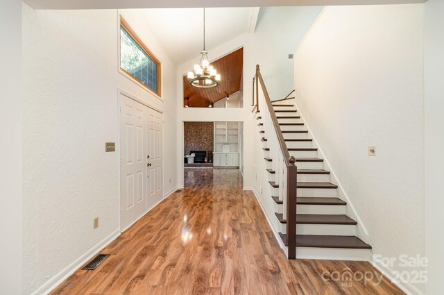 1006 Lost Cv, Weddington, NC 28104 - foyer featuring stairway, a chandelier, wood finished floors, and a high ceiling