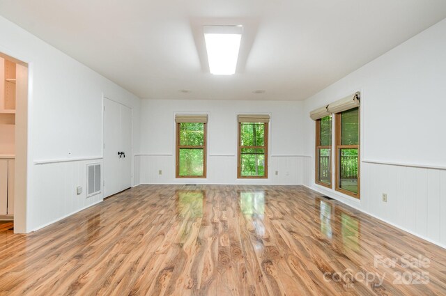 1006 Lost Cv, Weddington, NC 28104 - unfurnished room featuring light wood-style flooring, a wainscoted wall, and a decorative wall