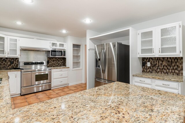 1006 Lost Cv, Weddington, NC 28104 - kitchen featuring appliances with stainless steel finishes, backsplash, light tile patterned floors, light stone countertops, and recessed lighting