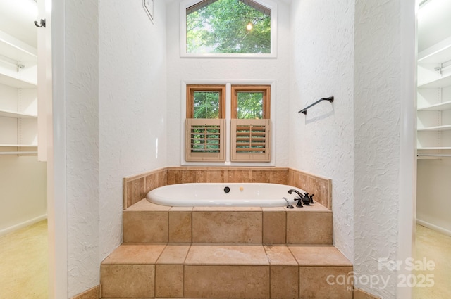 1006 Lost Cv, Weddington, NC 28104 - bathroom with a textured wall, a garden tub, and a spacious closet