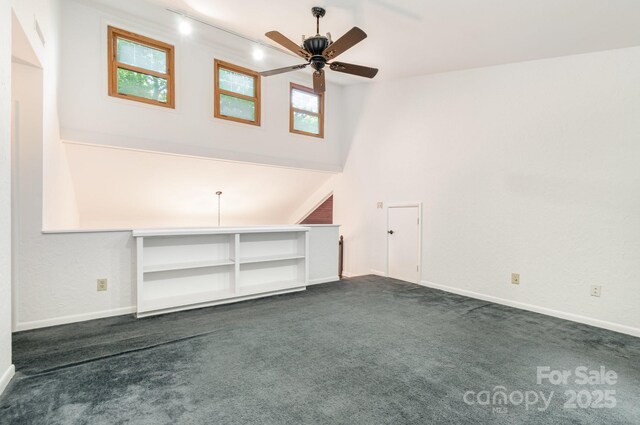 1006 Lost Cv, Weddington, NC 28104 - unfurnished living room featuring dark carpet, a ceiling fan, track lighting, and a towering ceiling