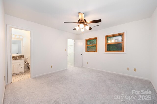 1006 Lost Cv, Weddington, NC 28104 - unfurnished bedroom with light colored carpet, baseboards, connected bathroom, a spacious closet, and a ceiling fan
