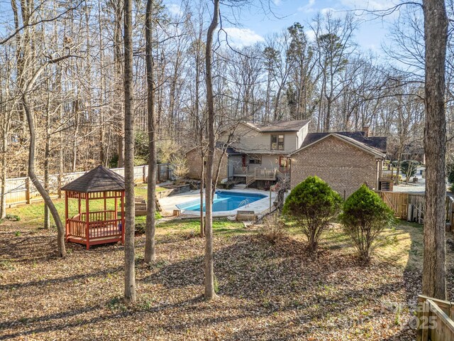 1006 Lost Cv, Weddington, NC 28104 - back of house with a gazebo, brick siding, a fenced backyard, and a chimney