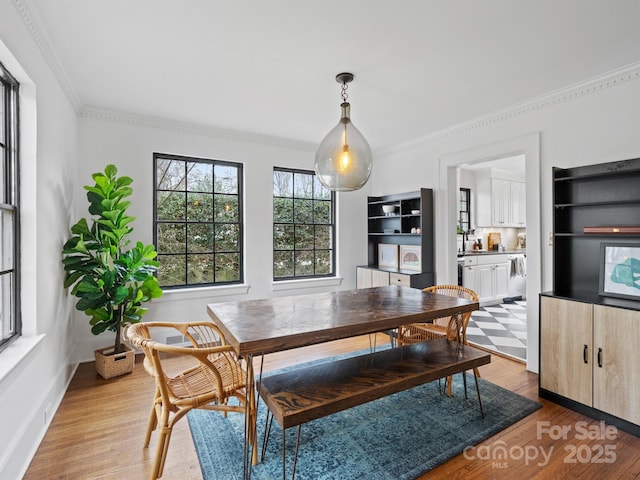 dining room featuring light hardwood / wood-style flooring and ornamental molding