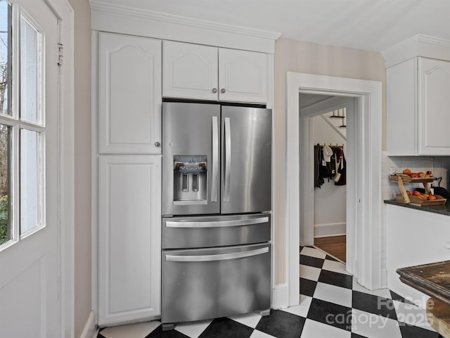 kitchen featuring tasteful backsplash, stainless steel fridge with ice dispenser, and white cabinets