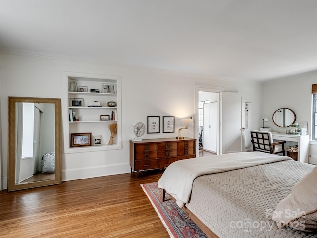 bedroom featuring hardwood / wood-style flooring and crown molding