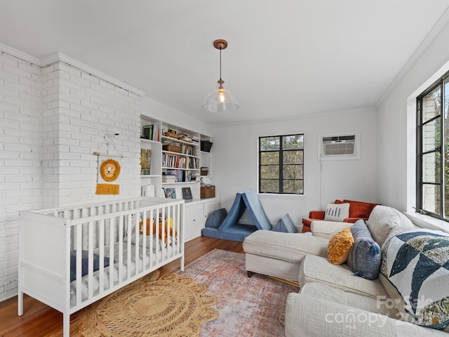 bedroom featuring a wall mounted air conditioner, hardwood / wood-style floors, and multiple windows