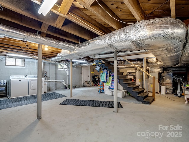 basement featuring water heater and independent washer and dryer