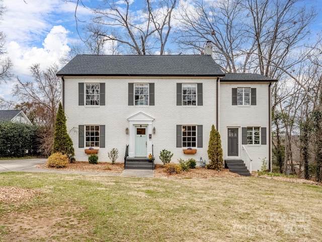 colonial-style house with a front yard