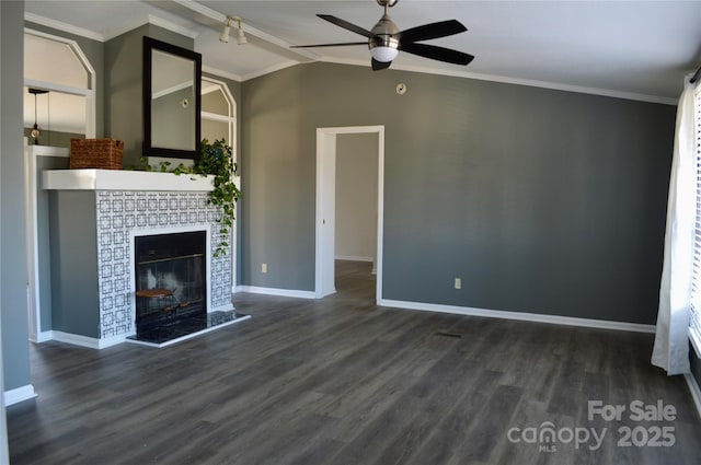 unfurnished living room featuring dark wood-type flooring, a tile fireplace, ceiling fan, ornamental molding, and vaulted ceiling