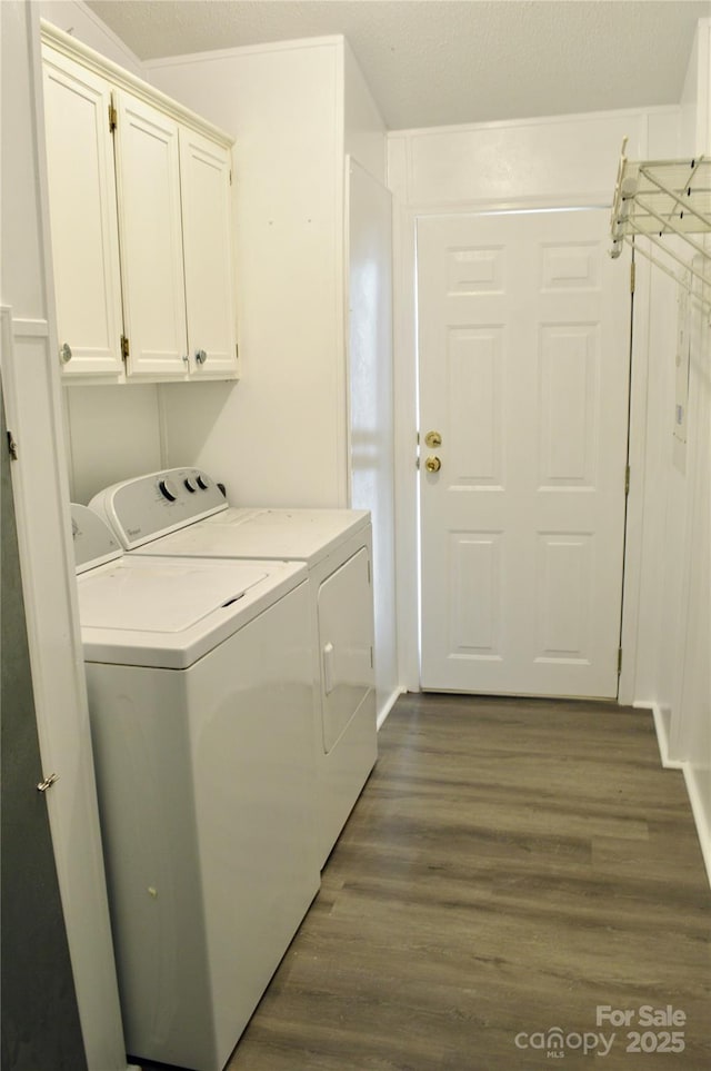 laundry room with cabinets, dark hardwood / wood-style floors, and washing machine and clothes dryer