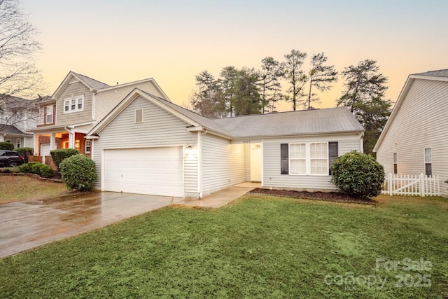 view of front of home with a garage and a yard