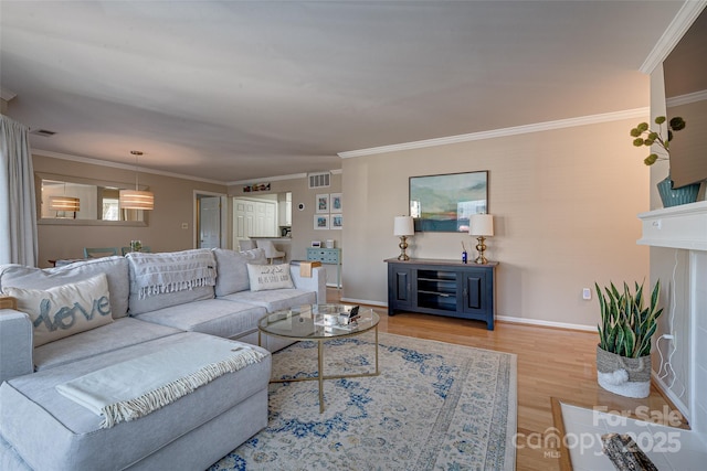 living room with ornamental molding and light hardwood / wood-style floors