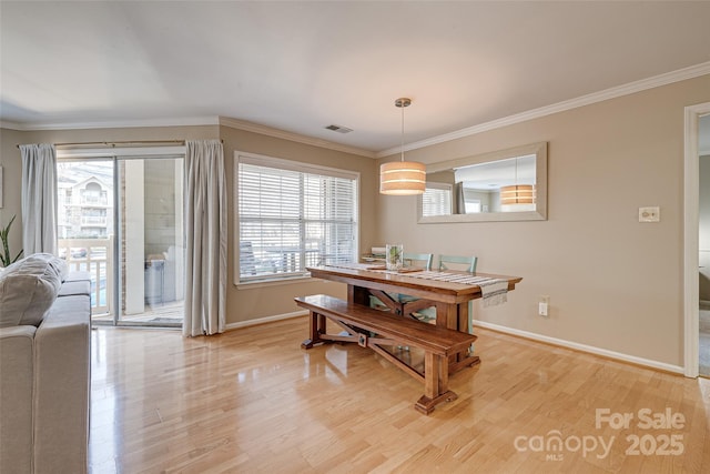 dining area featuring crown molding and light wood-type flooring