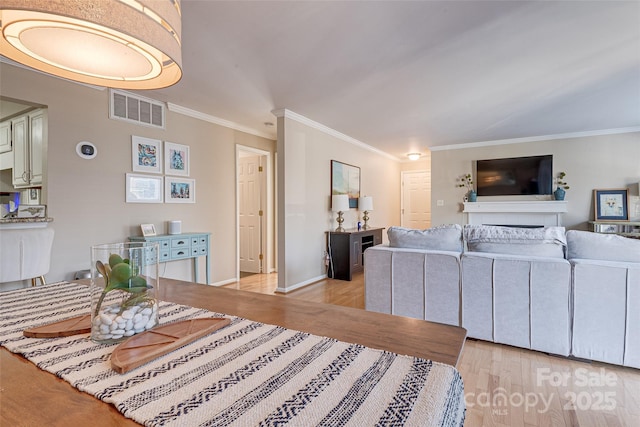 living room featuring ornamental molding and light wood-type flooring