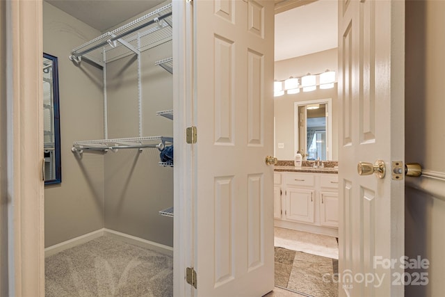 spacious closet featuring light colored carpet