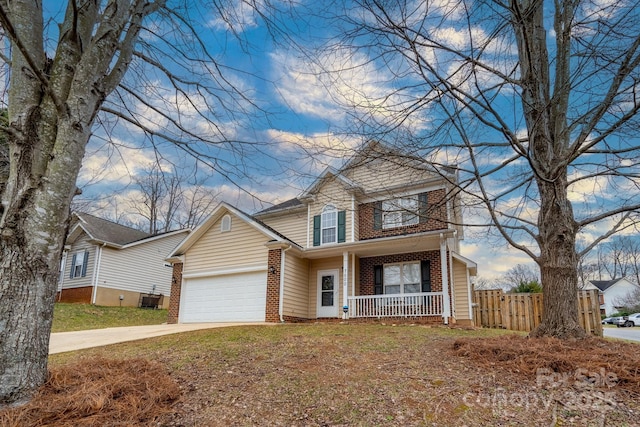 view of front property featuring a garage, a porch, and central AC