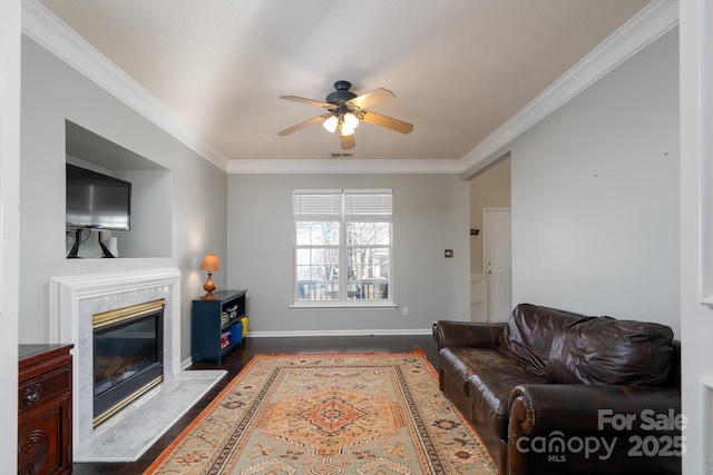 living room with dark wood-type flooring, a fireplace, ornamental molding, and ceiling fan