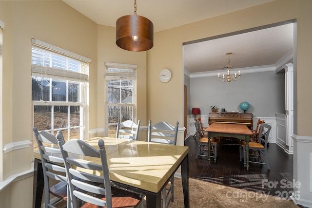 dining room with an inviting chandelier, hardwood / wood-style floors, ornamental molding, and decorative columns